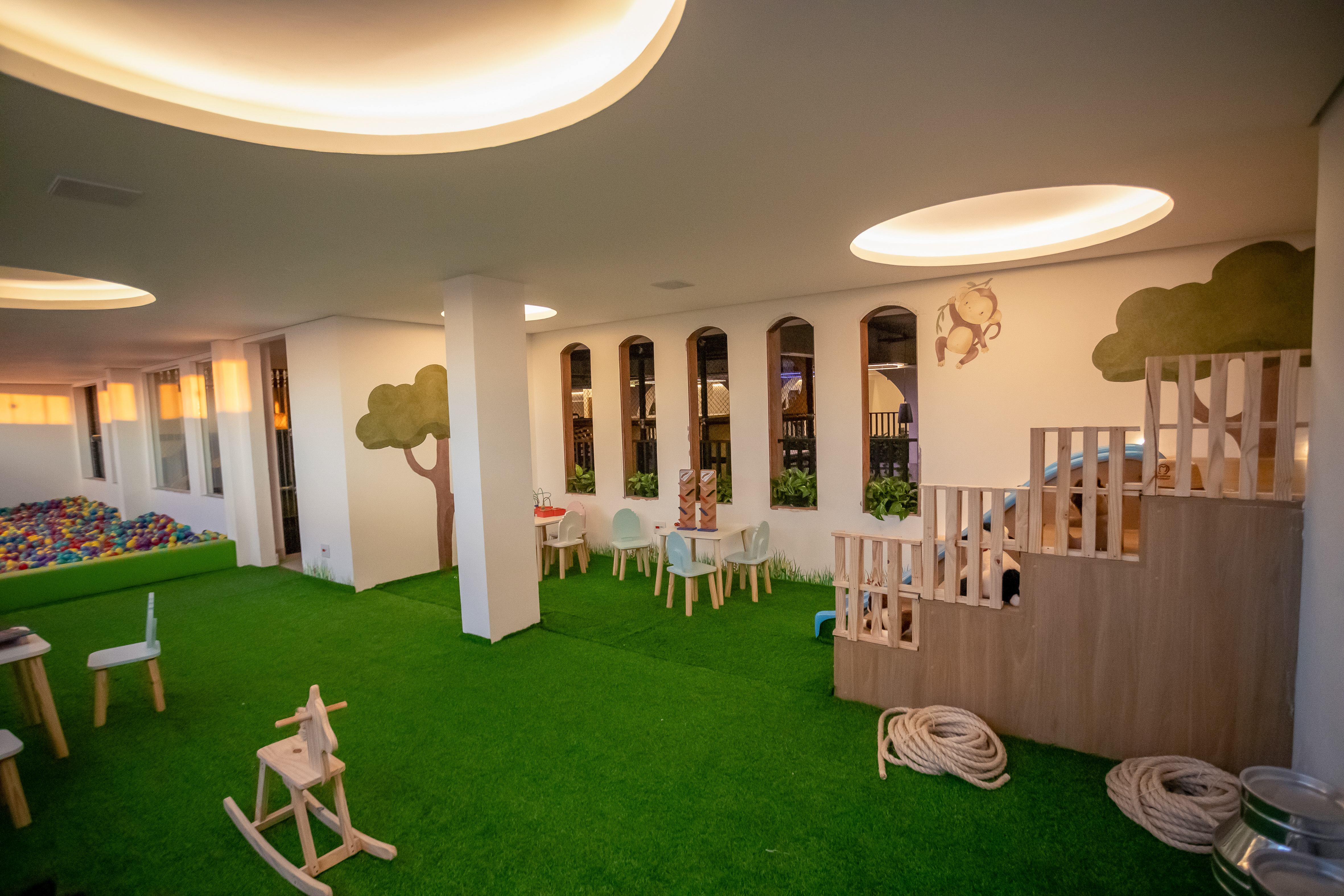 Área baby da Casa do Sol Estúdios com brinquedos, grama sintética e iluminação suave